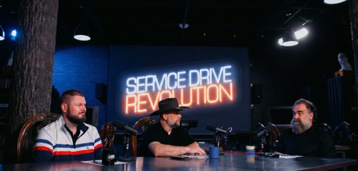 Service manager holding a focused one-on-one coaching meeting with a service advisor